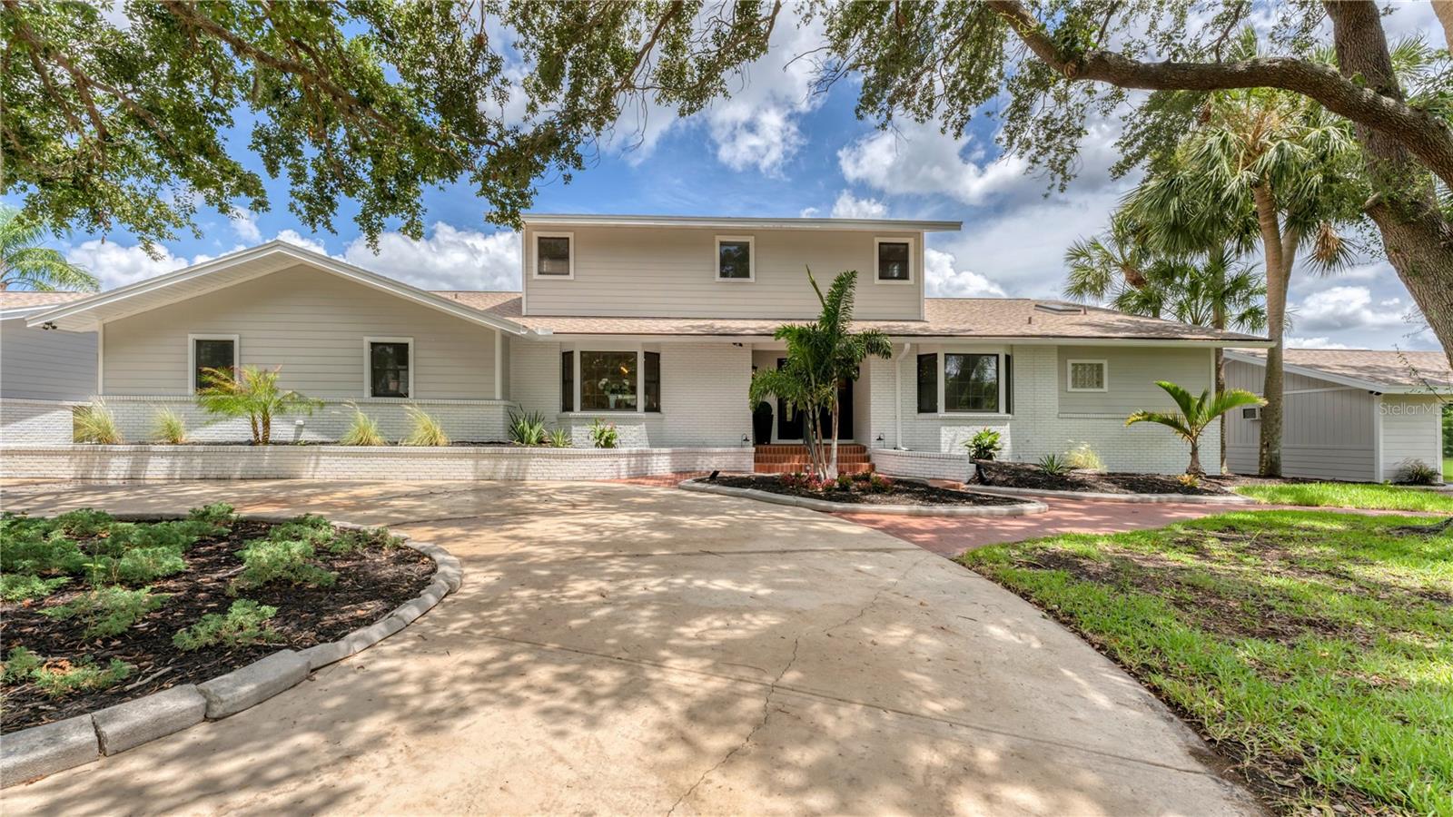 Circle driveway into front of 2 story waterfront pool home in cul-de-sac