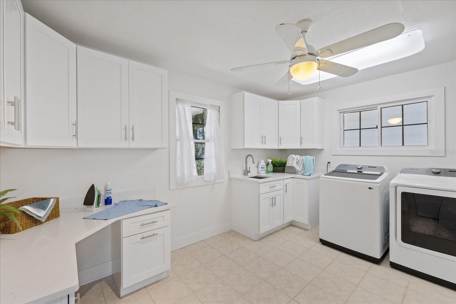 Spacious laundry room with desk and storage