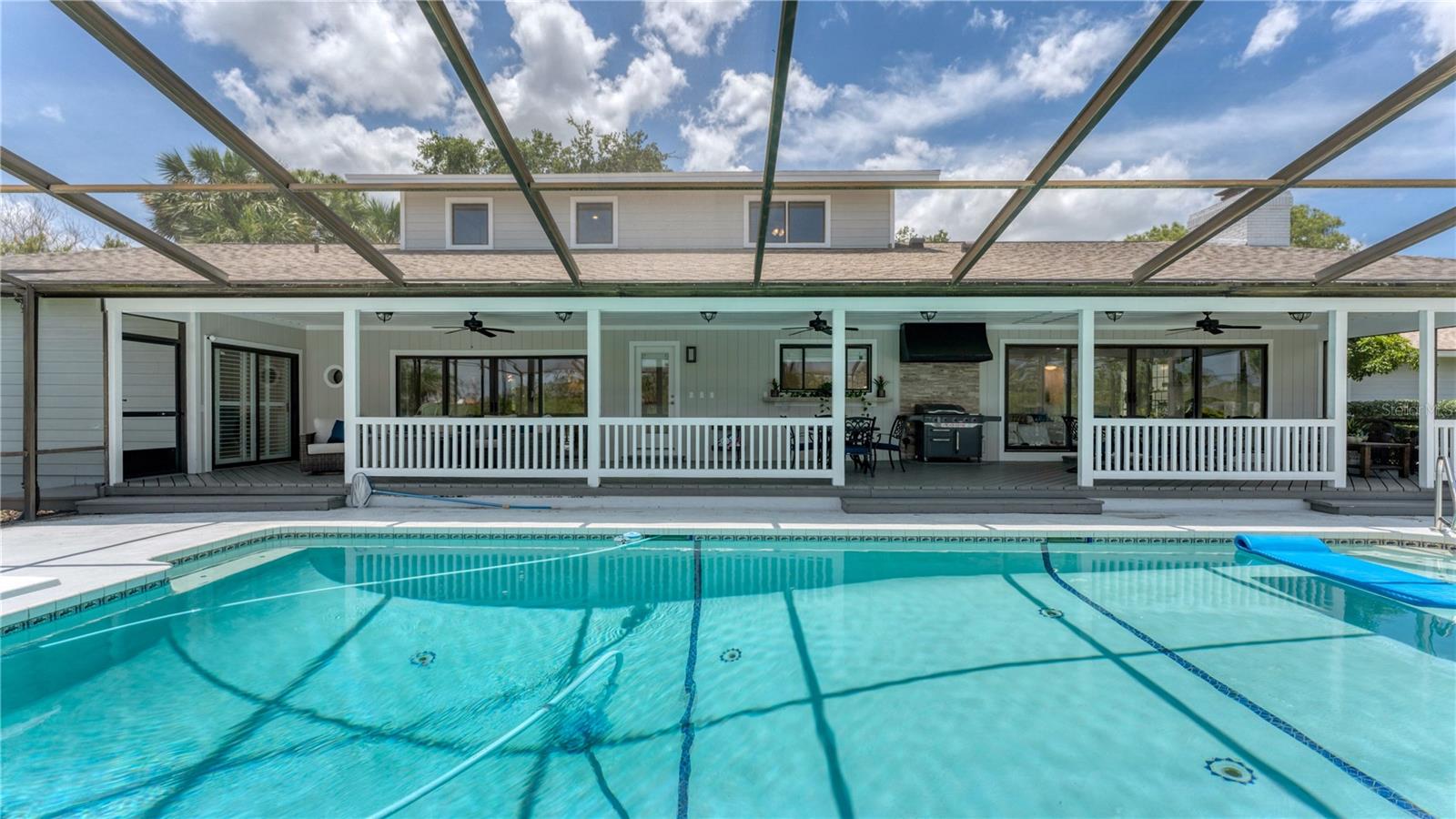View of pool and covered porch under screen(previously staged)