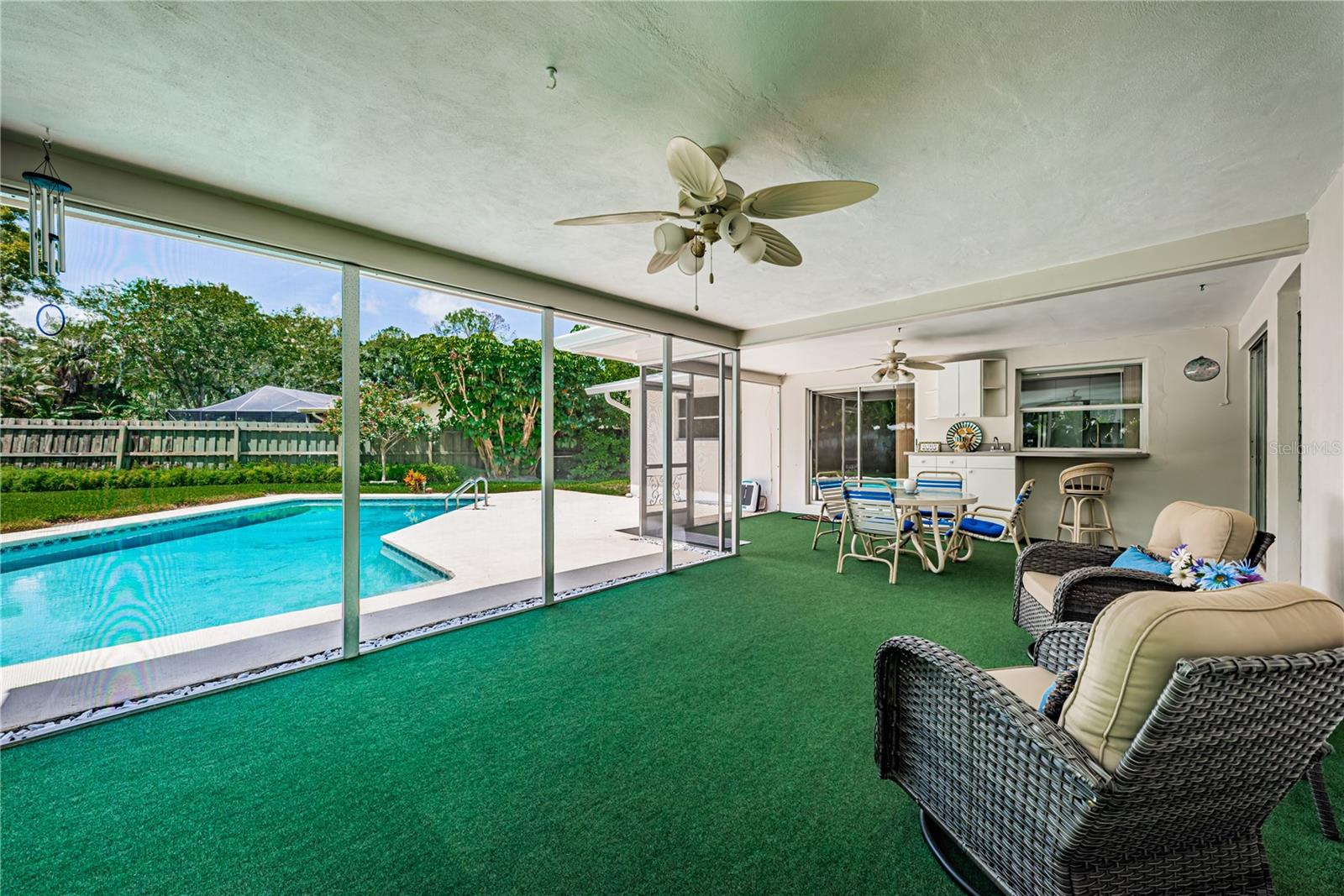 Enjoy   your time out of the sun in this covered and screened lanai