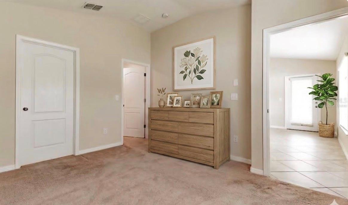 Decor virtually staged. Primary Bedroom Open door is walk in closet