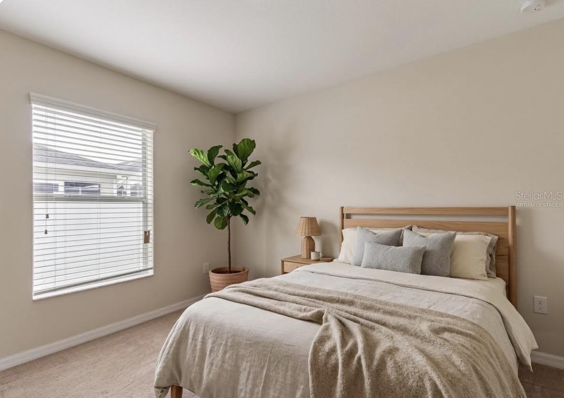 Decor virtually staged. Back left bedroom.