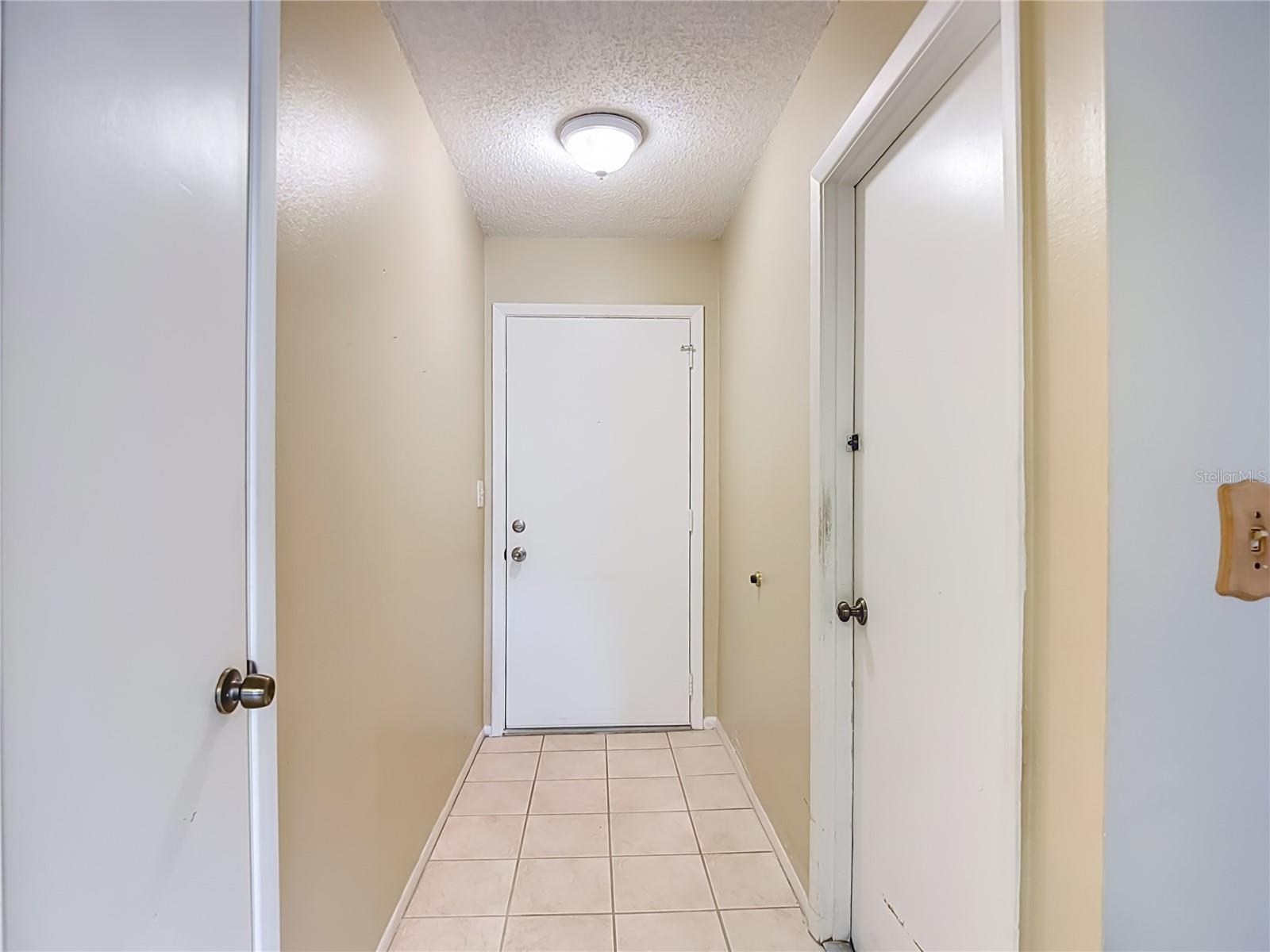 Facing front door - hallway closet to the left and garage access door to the right.