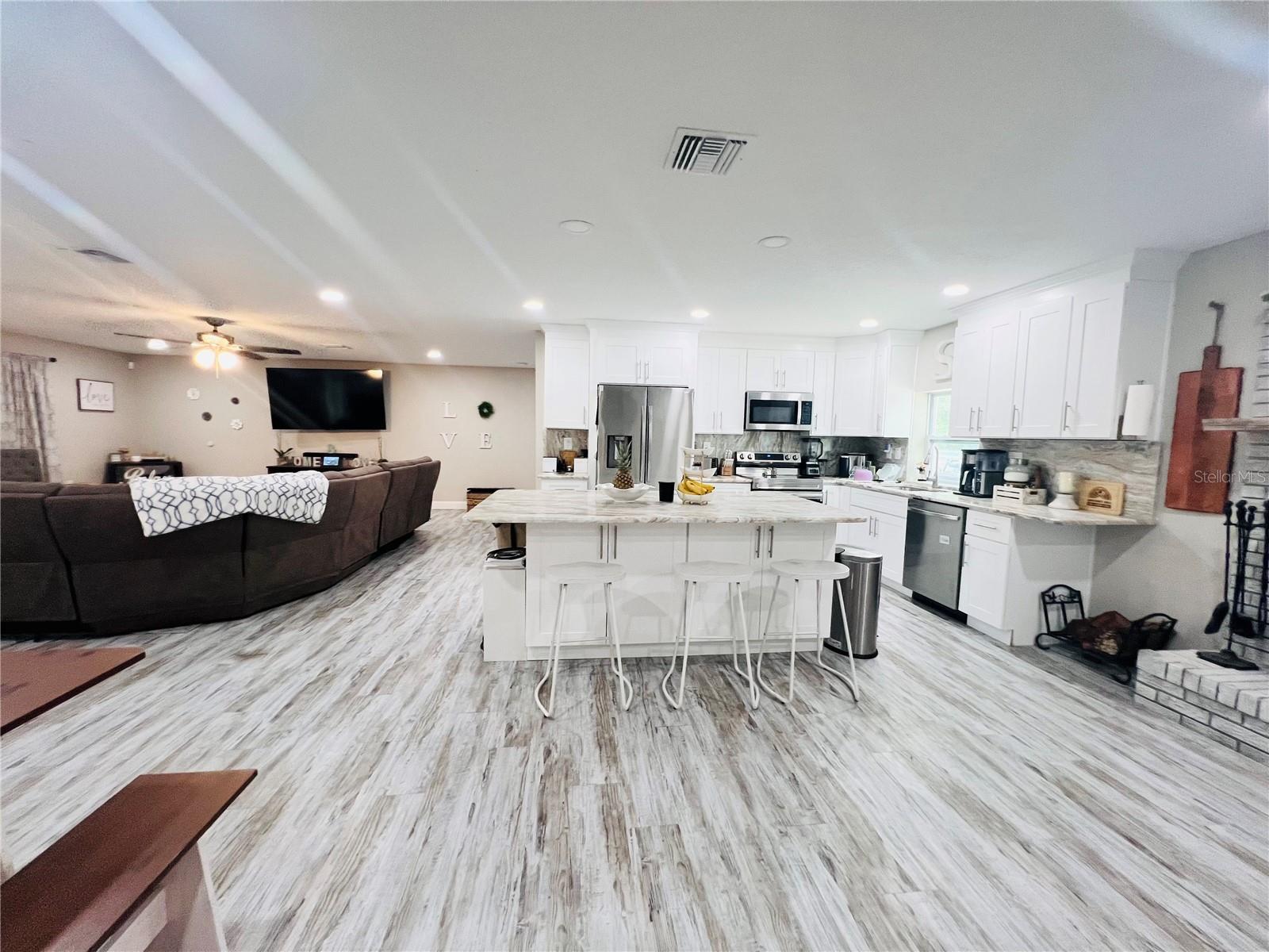 VIEW OF KITCHEN AND LIVING AREA FROM HALL WAY