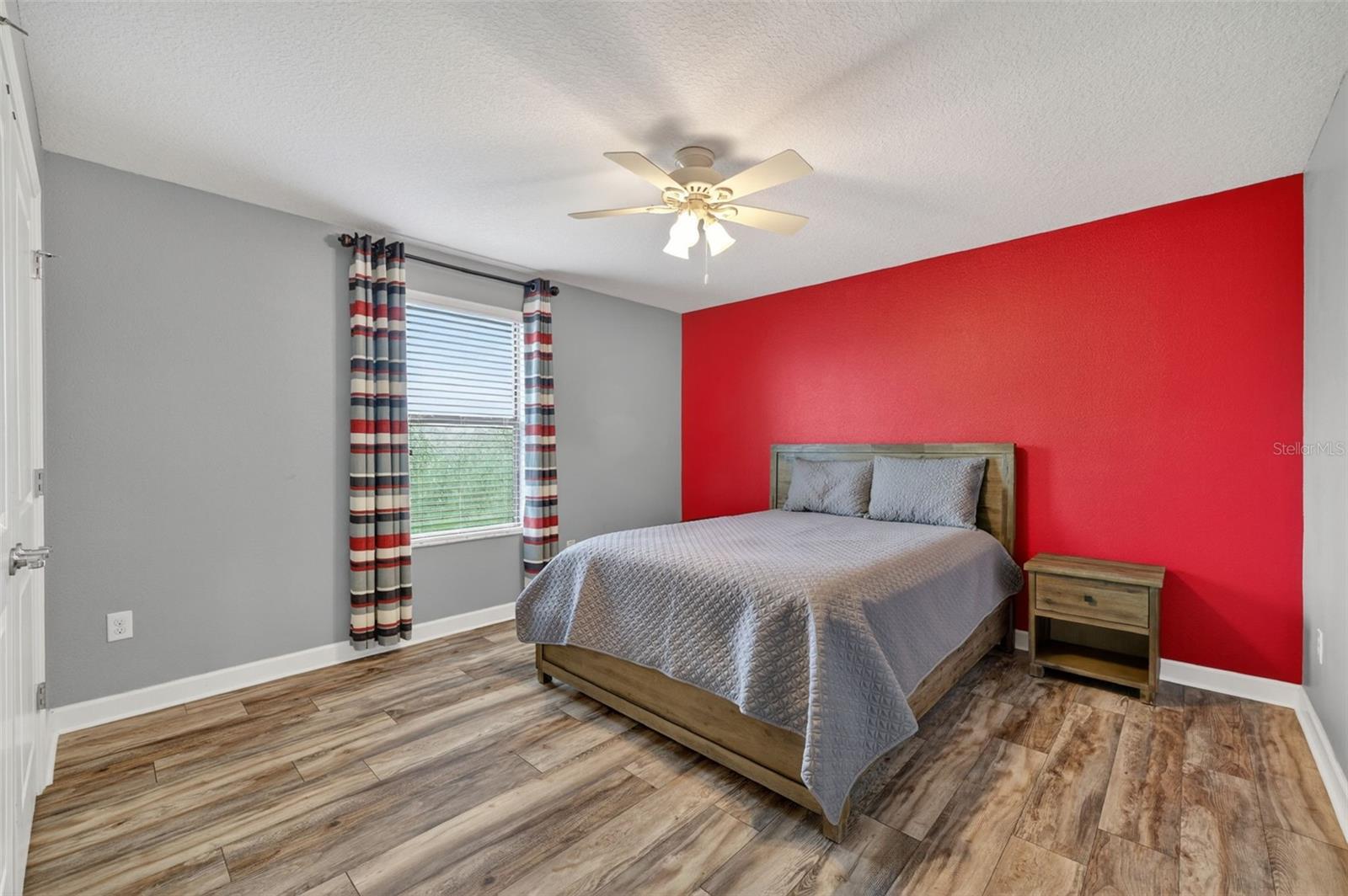 Bedroom #4 with LVP Flooring, Ceiling Fan, Built-In Closet, Accent Wall and Window Overlooing the Pond and View of Waterleaf Community!
