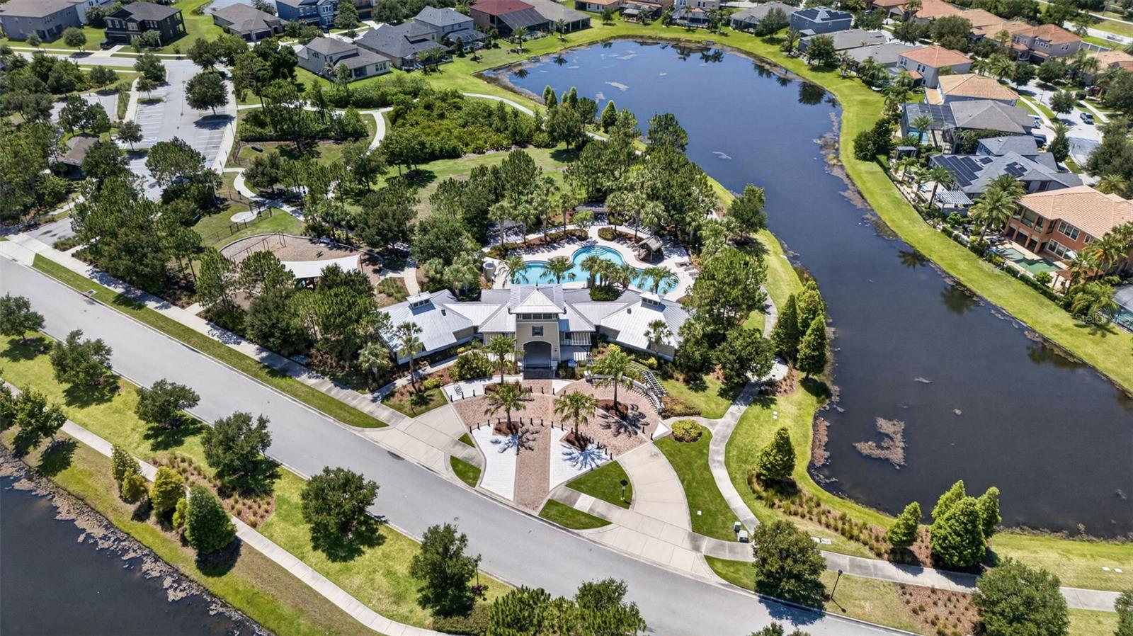 Aerial View of Amenities with Clubhouse, Resort Style Pool, Playground/Park, Sports Court, Dog Park, Walking Trails and Water View in Waterleaf Community!
