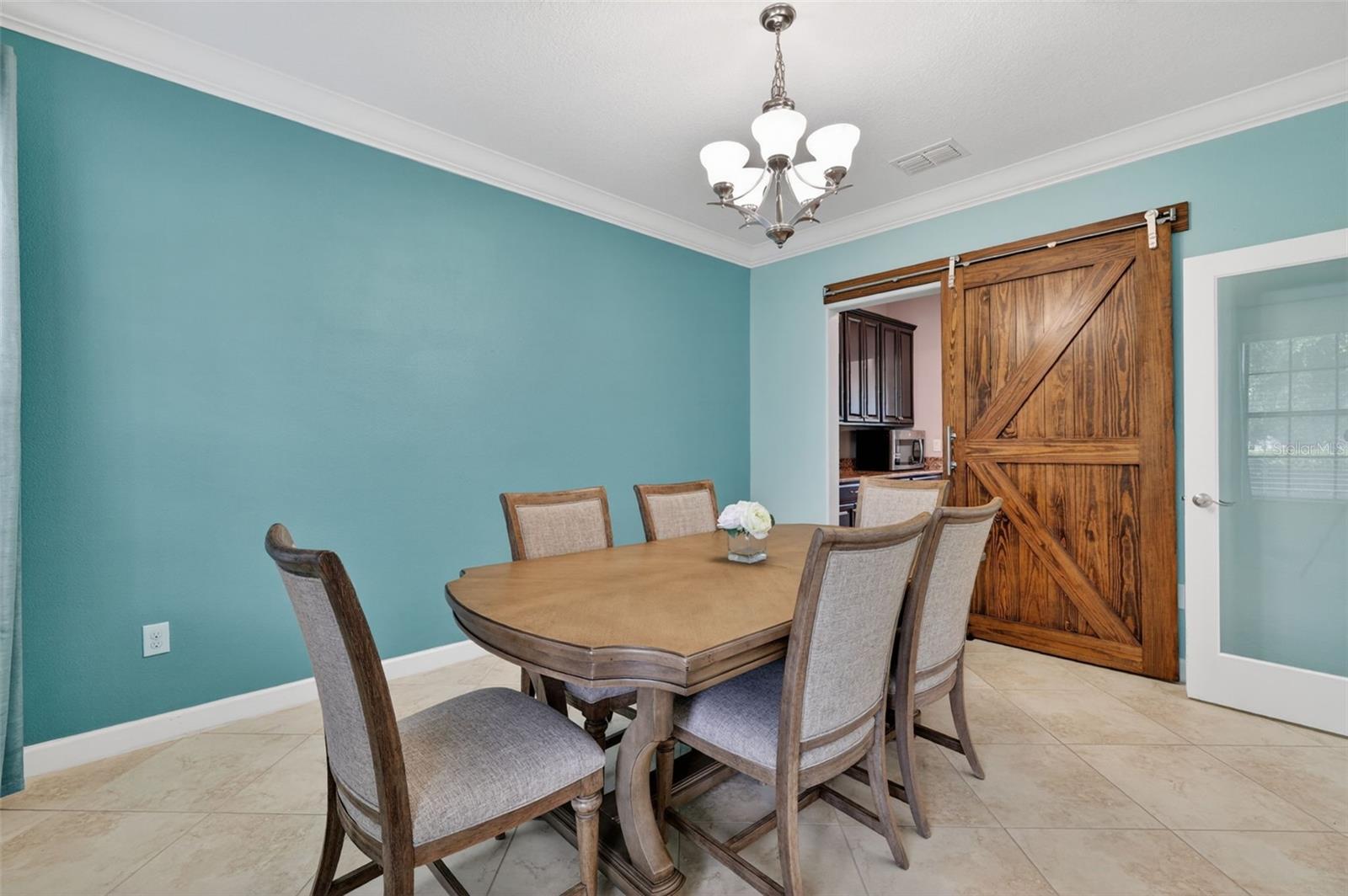 Flex Room with Crown Molding, Chandelier, and Barn Door Entry to Butler's Pantry