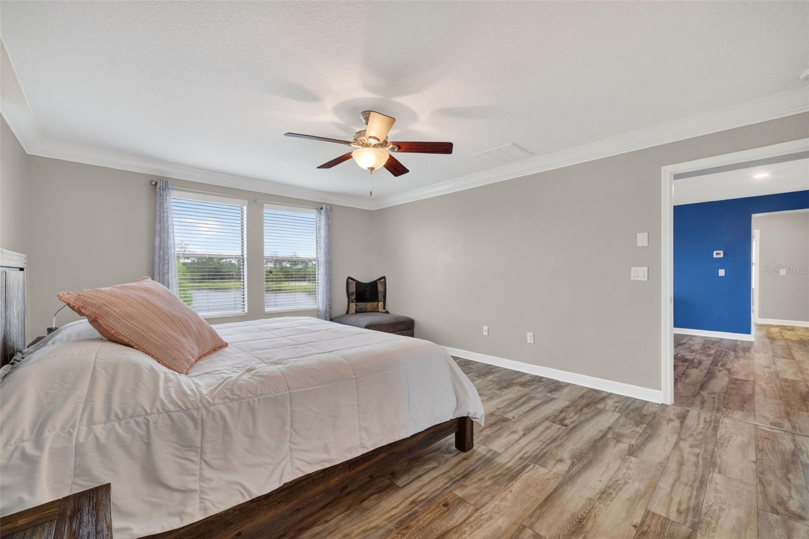 Primary Suite with LVP Floors, Crown Molding, Ceiling Fan, En-Suite Primary Bathroom, Windows Overlooking the View in Waterleaf Community! Enough Room for a King Bed and creating a Sitting Area.