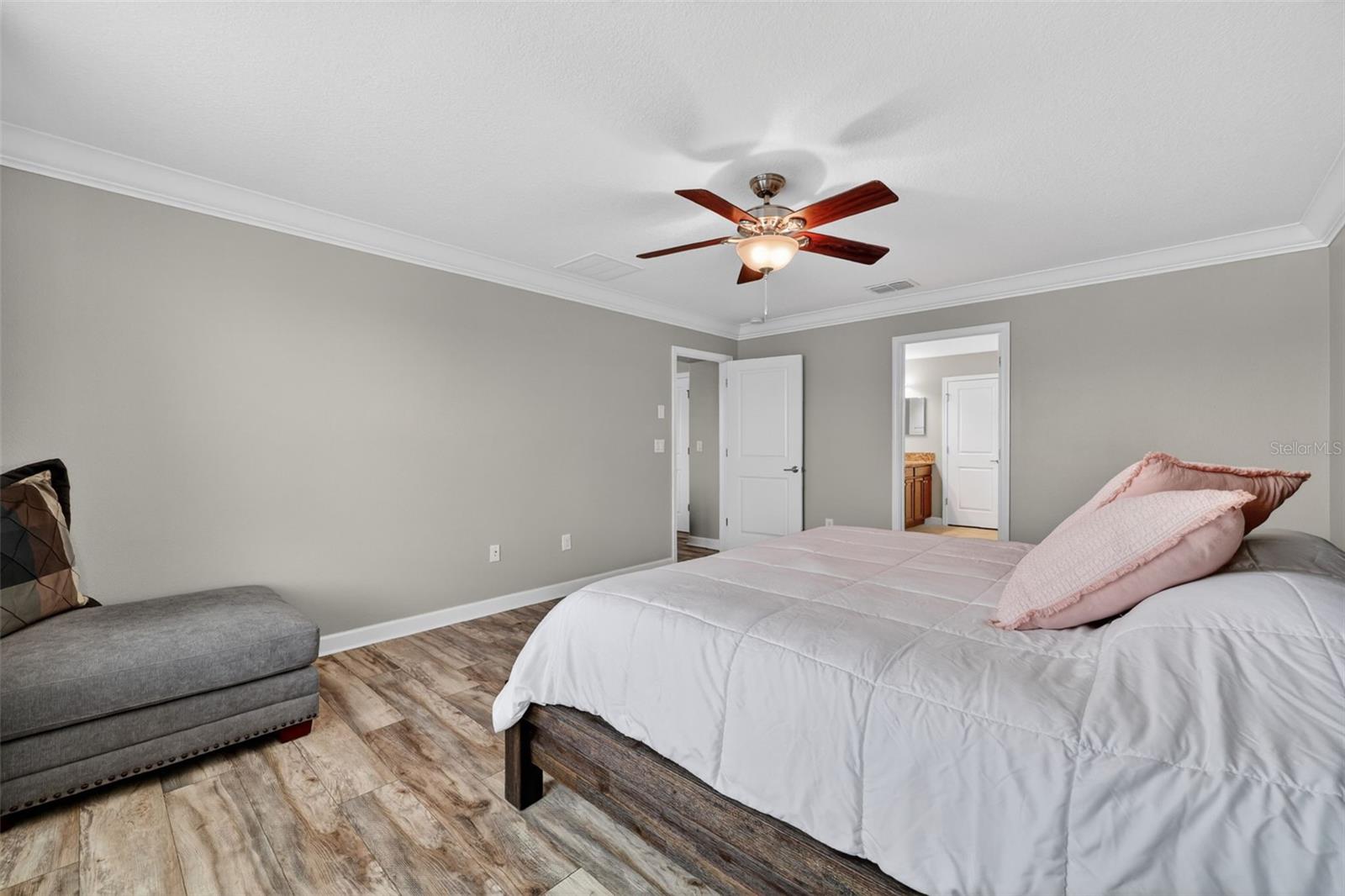 Primary Suite with LVP Floors, Crown Molding, Ceiling Fan, En-Suite Primary Bathroom, Windows Overlooking the View in Waterleaf Community! Enough Room for a King Bed and creating a Sitting Area.