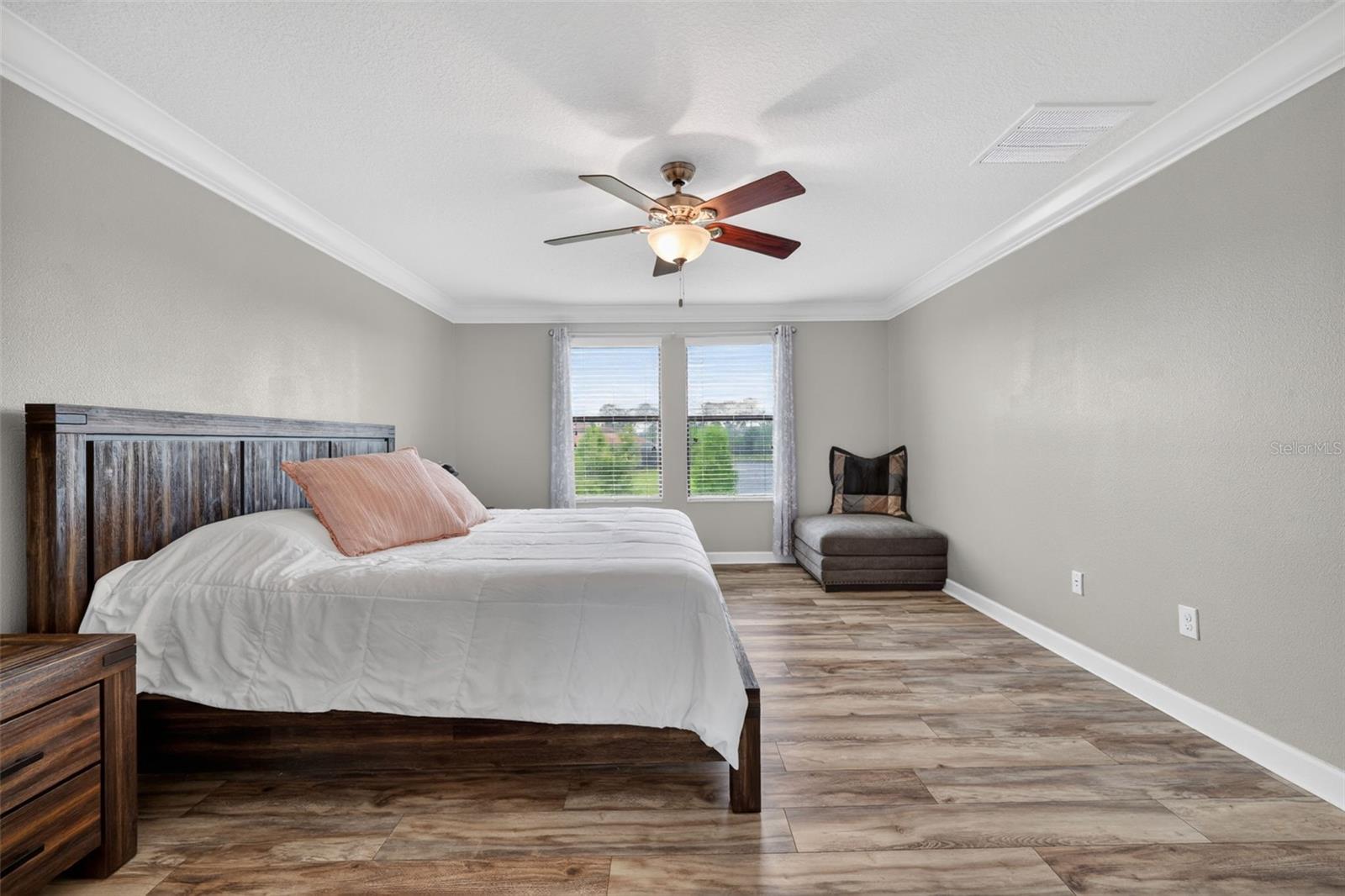 Primary Suite with LVP Floors, Crown Molding, Ceiling Fan, En-Suite Primary Bathroom, Windows Overlooking the View in Waterleaf Community! Enough Room for a King Bed and creating a Sitting Area.