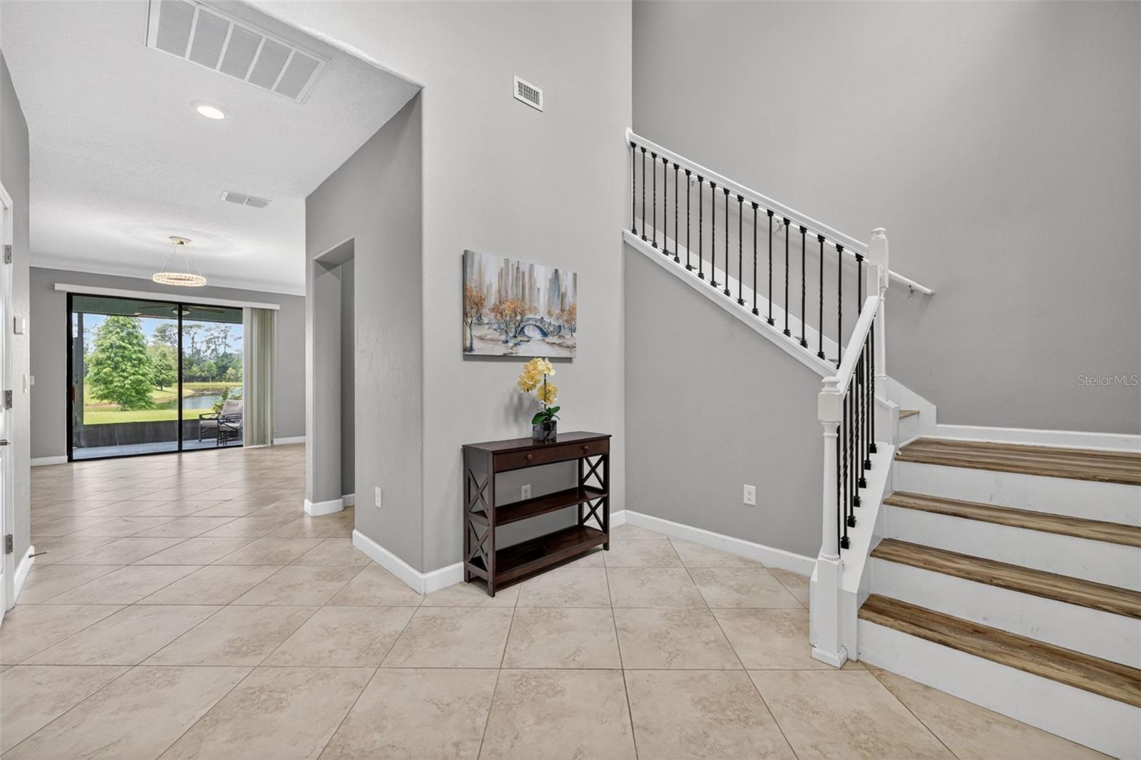 Foyer with Cathedral High Ceiling, View to Tranquil Pond, Alcove, and Staircase