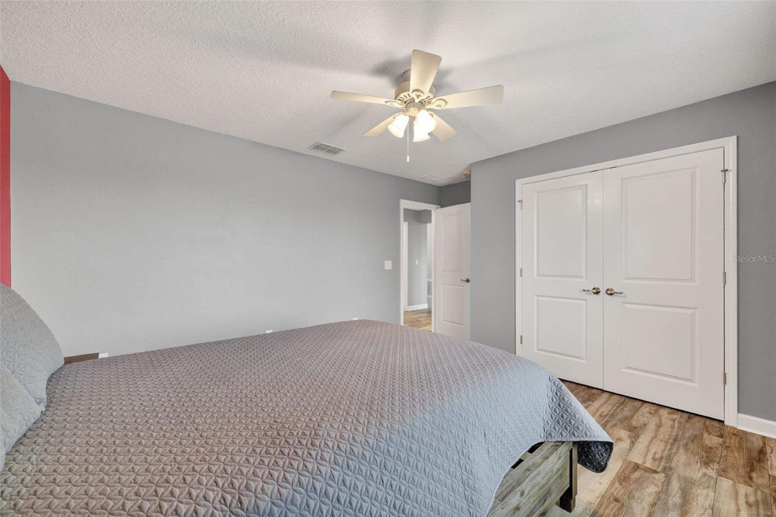Bedroom #4 with LVP Flooring, Ceiling Fan, Built-In Closet, Accent Wall and Window Overlooing the Pond and View of Waterleaf Community!