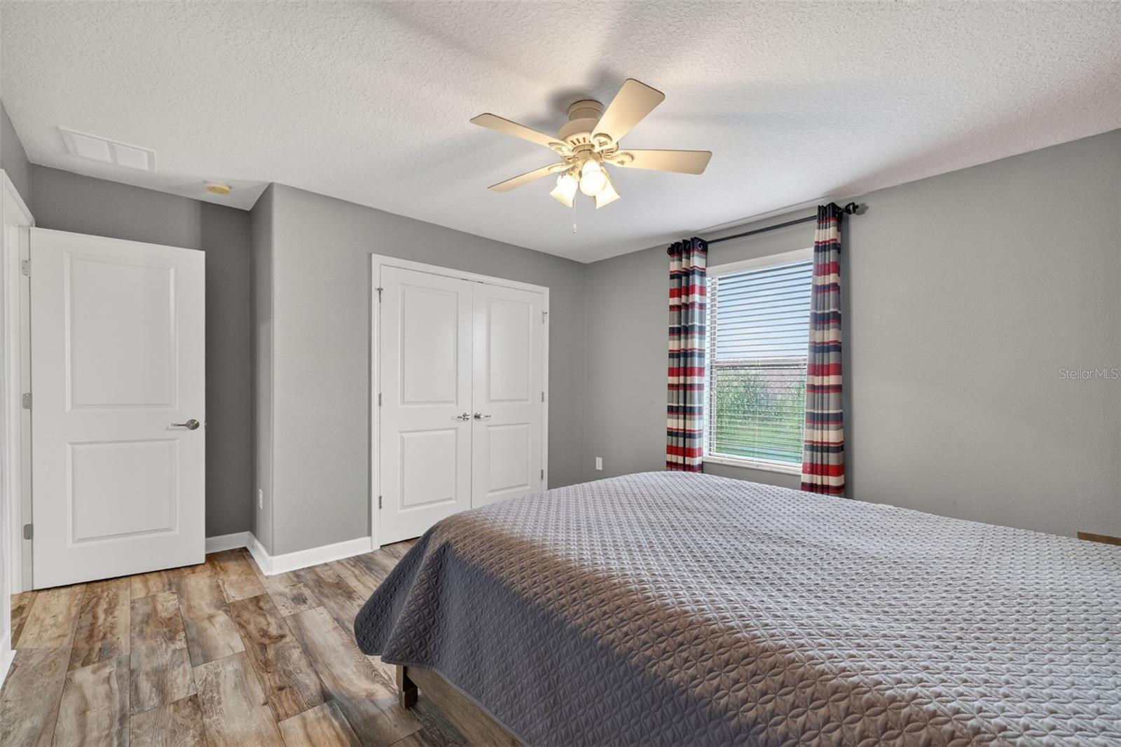 Bedroom #4 with LVP Flooring, Ceiling Fan, Built-In Closet, Accent Wall and Window Overlooing the Pond and View of Waterleaf Community!