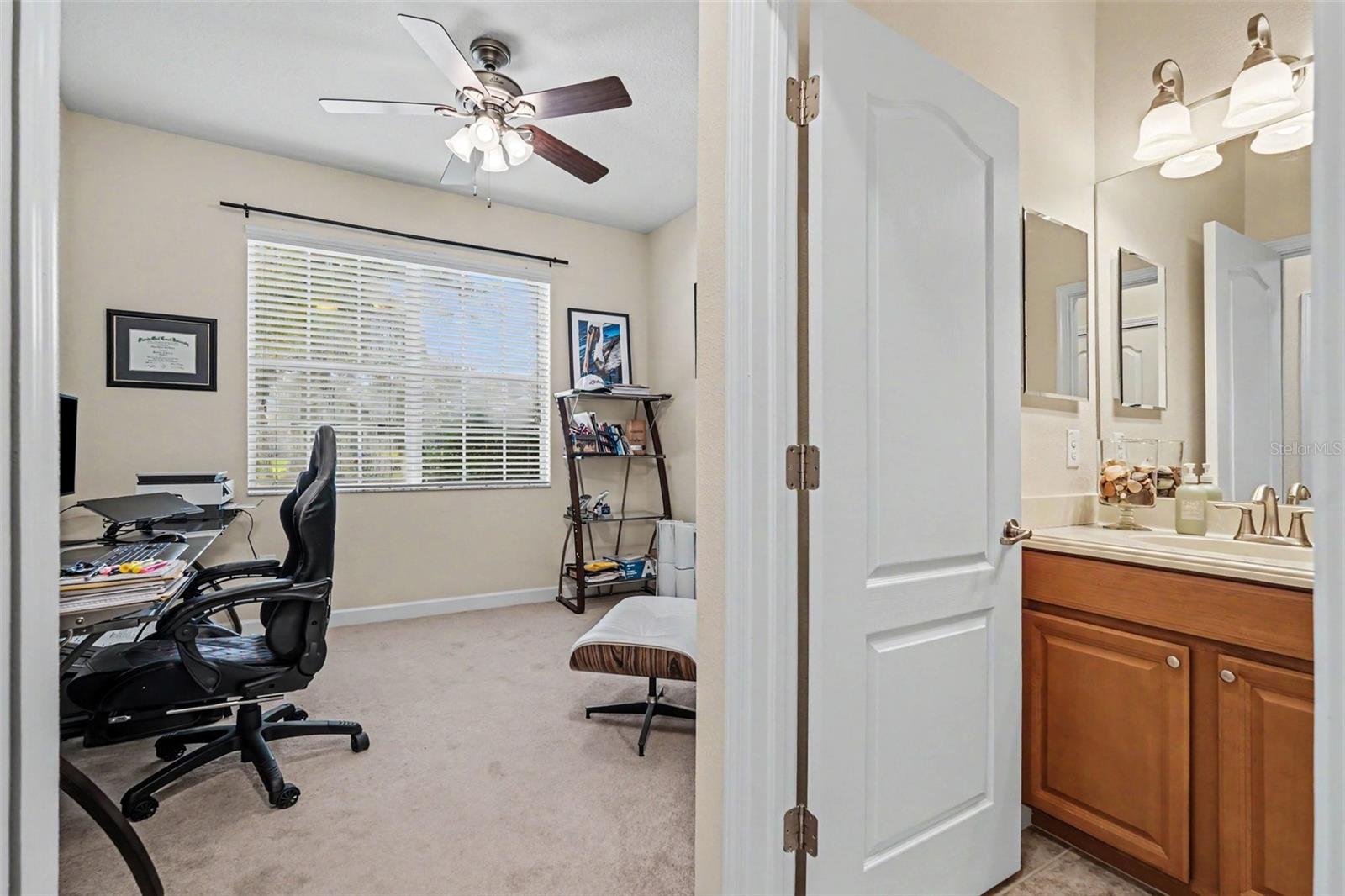 Bedroom two (junior suite via pocket door access) and adjacent full bathroom doorway showing split bedroom layout in Tampa FL 33647