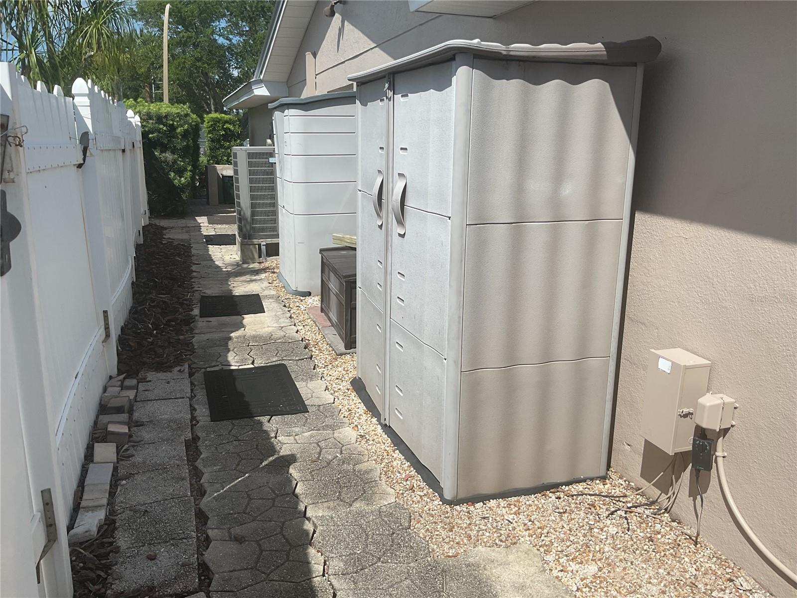 Fenced side of house with 2 storage sheds