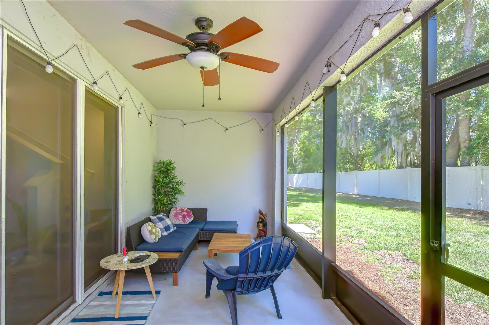 Relaxing screened-in back porch ideal for enjoying Florida's year-round sunshine in comfort.