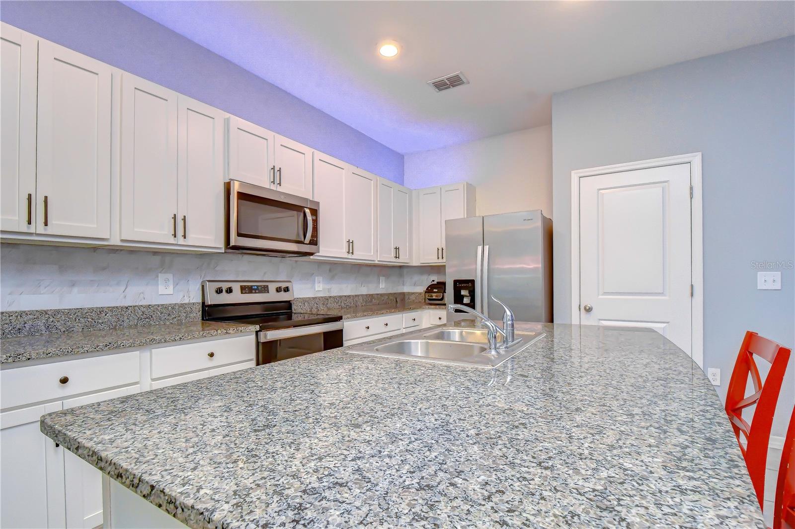 Generous counter space and beautiful cabinetry providing excellent storage for the home chef.