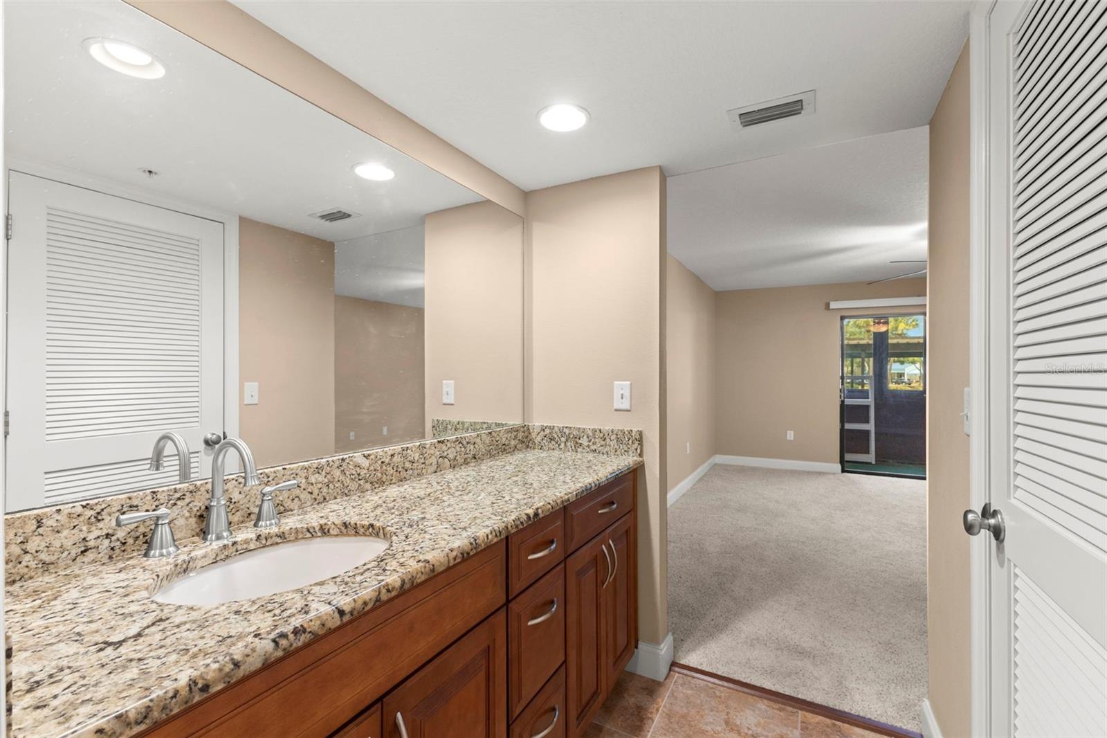 The ensuite bath offers a granite-topped vanity, ample storage, and convenient access from the primary bedroom.