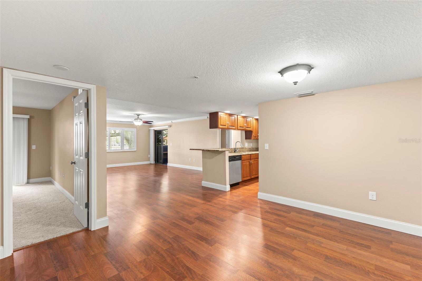Open-concept living and dining areas feature crown molding, wide baseboards, updated flooring, and easy access to the kitchen and enclosed porch.