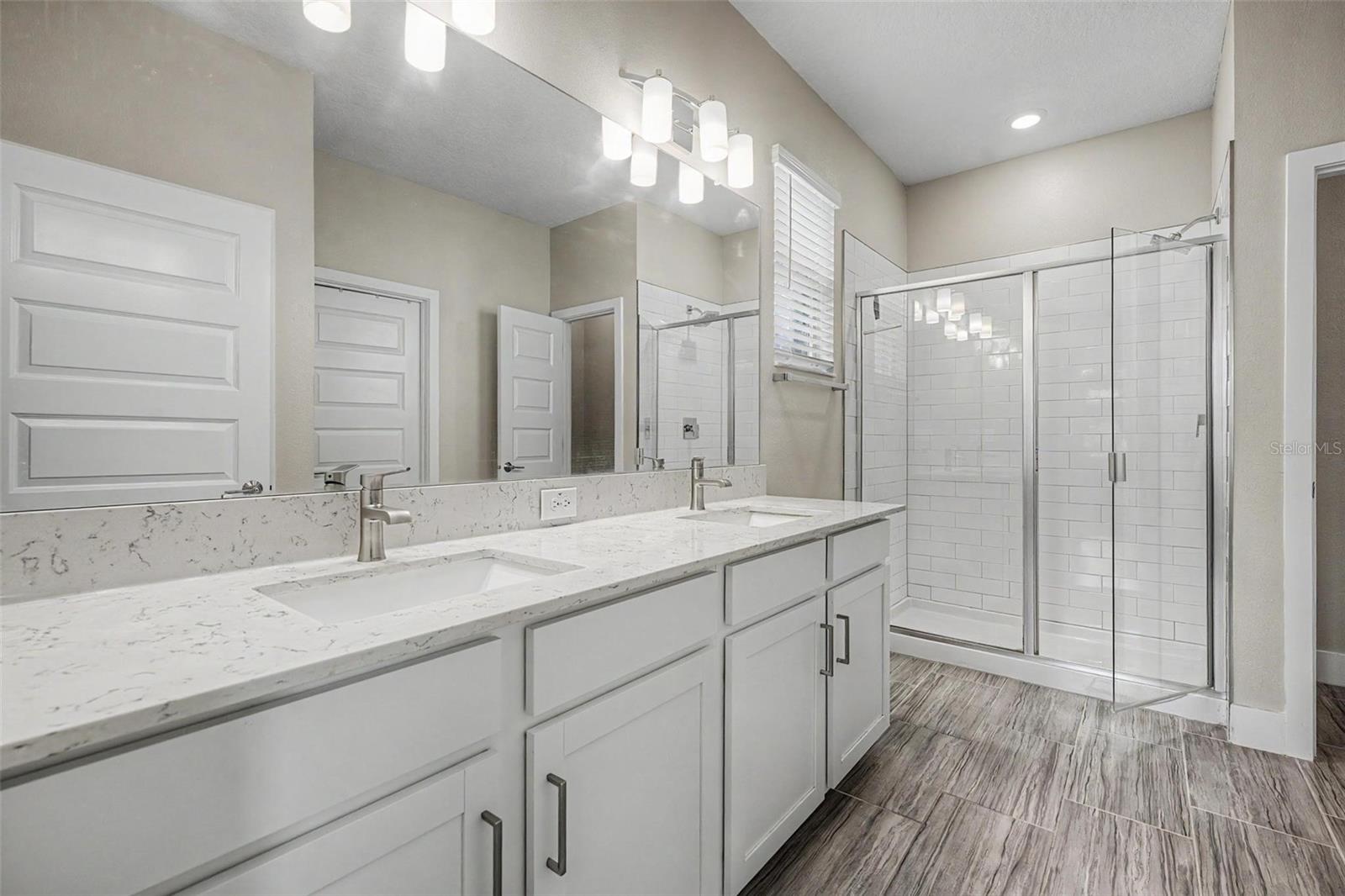 Double vanity, step-in shower and stone countertops