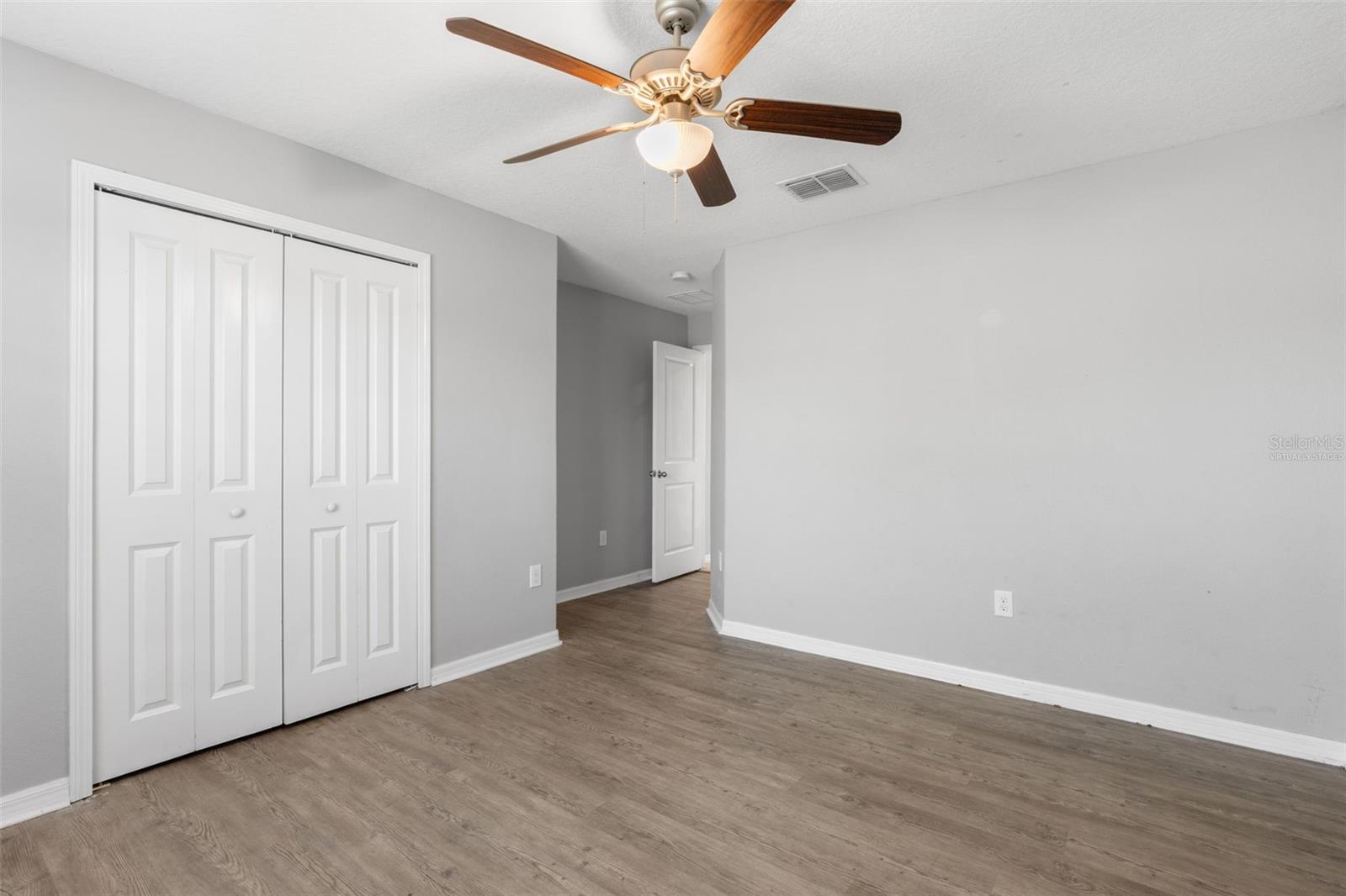 Virtually staged to show how comfortably the room accommodates a bed, nightstands, seating, and additional furniture.