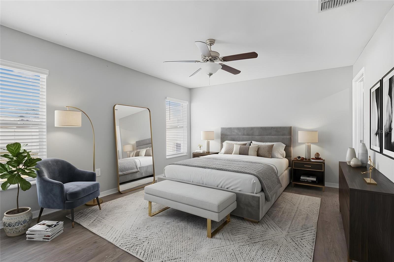 Two windows bring natural light into the spacious primary bedroom, which features laminate flooring, a ceiling fan, and room for a full furniture suite.