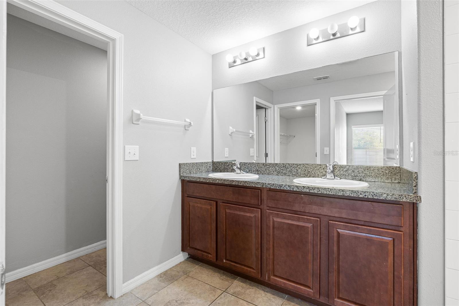 The primary bath features a tiled walk-in shower with a convenient handheld showerhead.