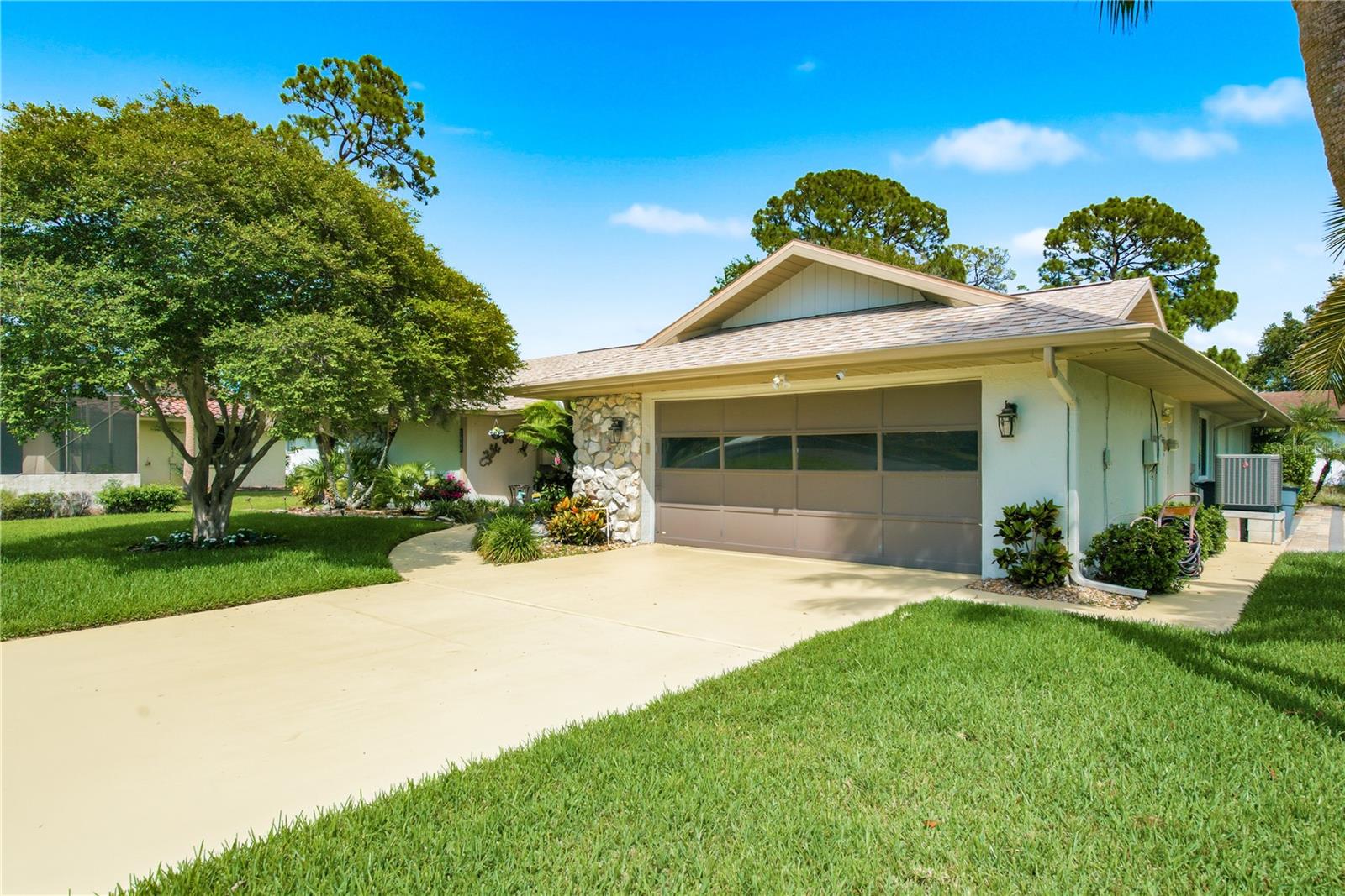 Spacious concrete driveway leading to a two car garage , offering plenty of parking and storage.