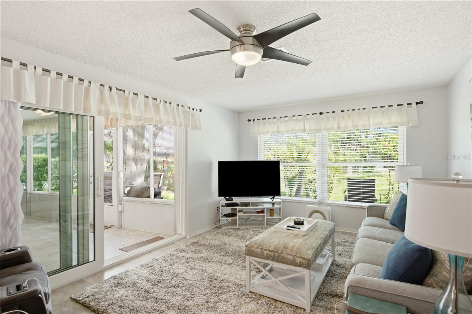 Inviting living room offering a seamless transition to the climate controlled Florida Room, complete with protective hurricane windows.