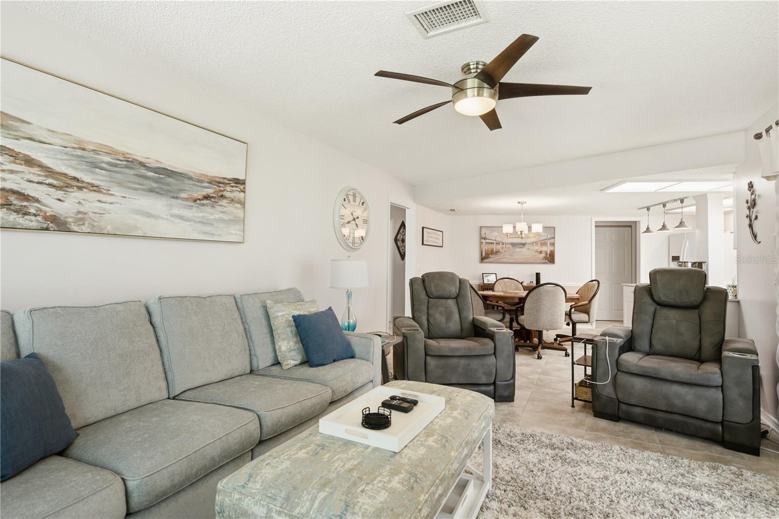 Another view of the spacious living room showcasing the open concept layout that flows seamlessly toward the kitchen and secondary seating area.