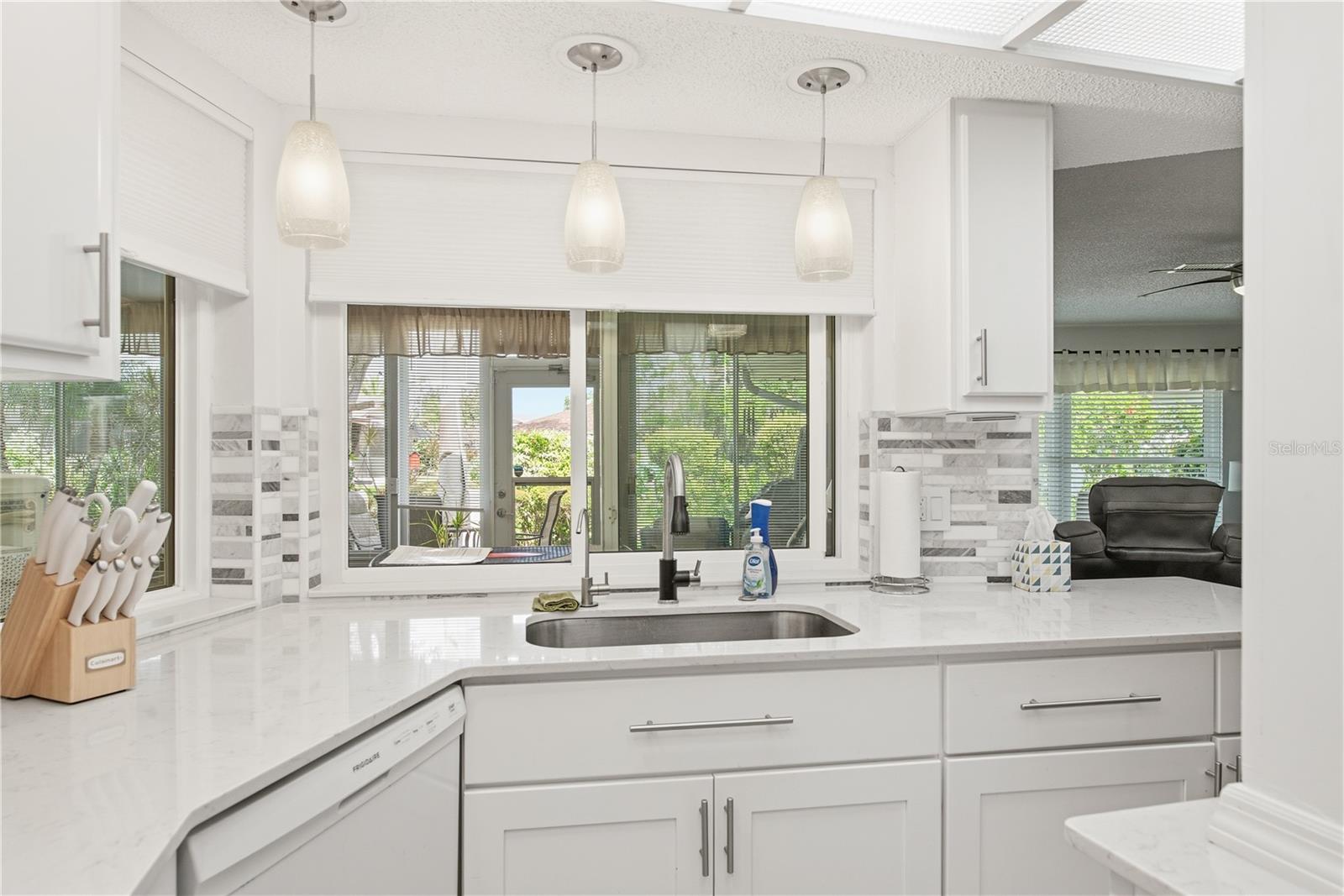 Updated kitchen featuring a large sink are with windows looking directly into the fully climate controlled Florida Room. Perfect for hosting and conversation.