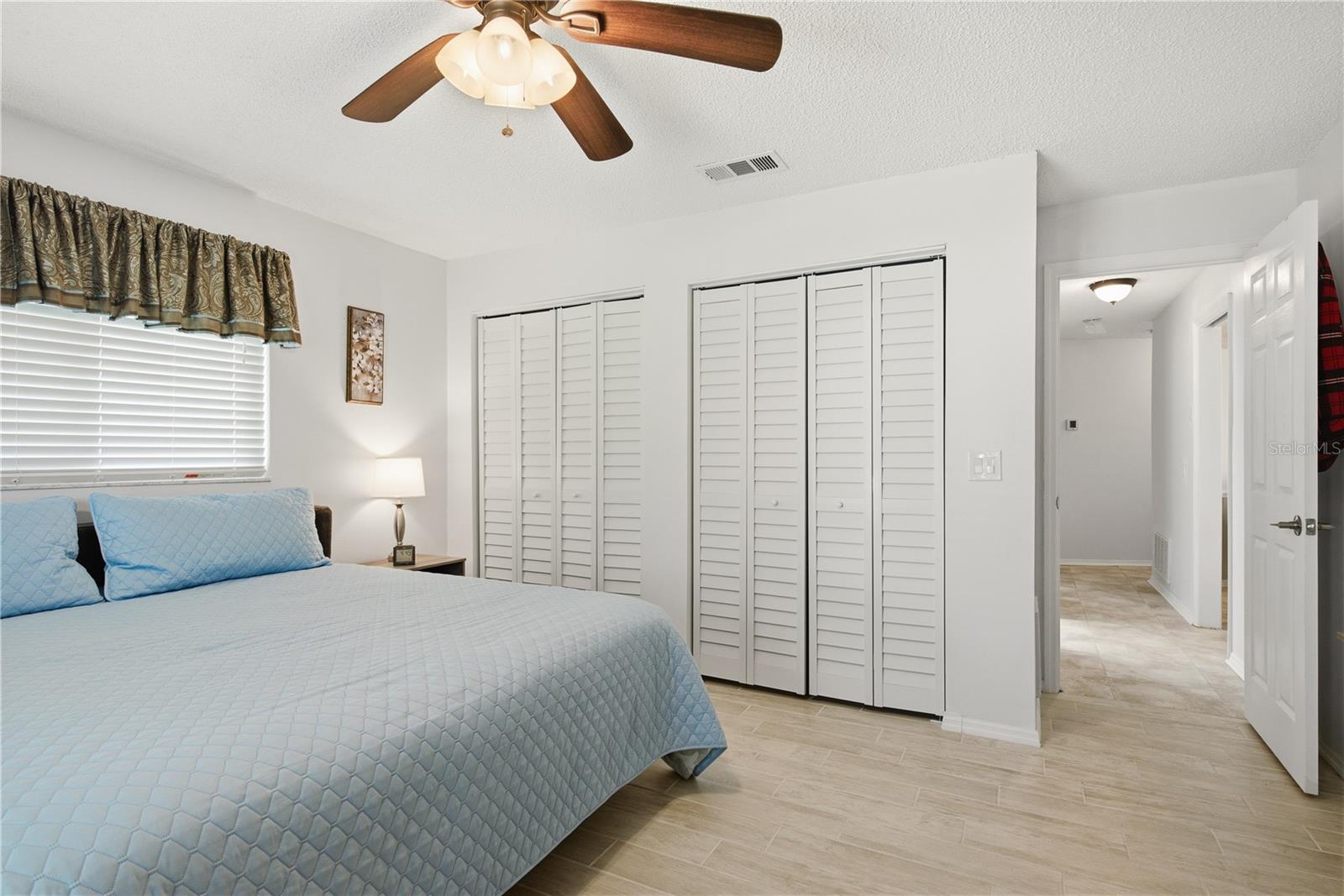 Another view of the second bedroom showcasing two large double closets and a wide entryway leading out to the hallway.