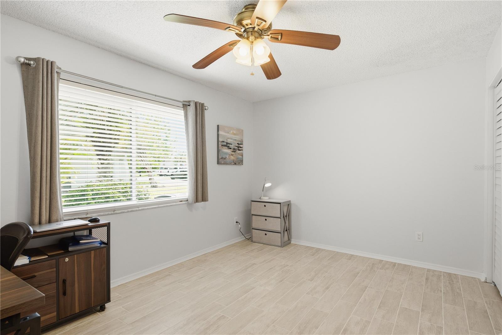 Versatile third bedroom, perfect for a home office or guest room with a large hurricane proof window bringing in natural light.