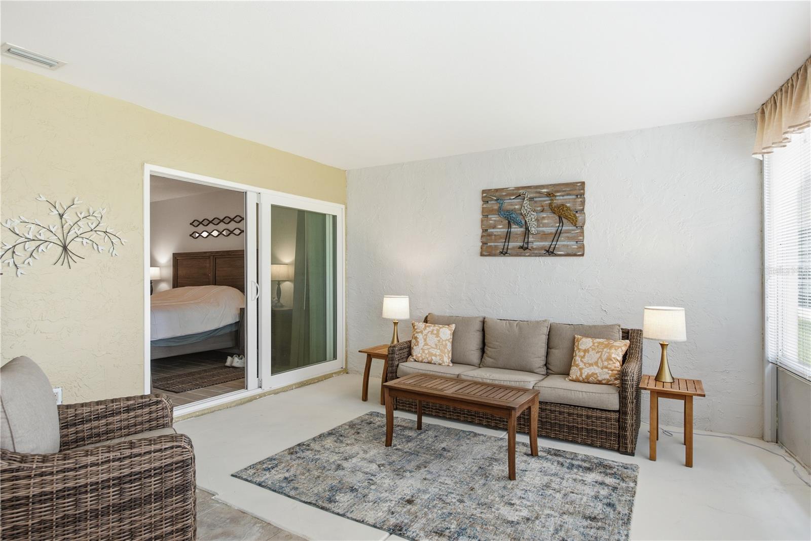 Cozy sitting are within the massive Florida Room, highlighting large sliding glass doors that lead directly back into the private primary bedroom.