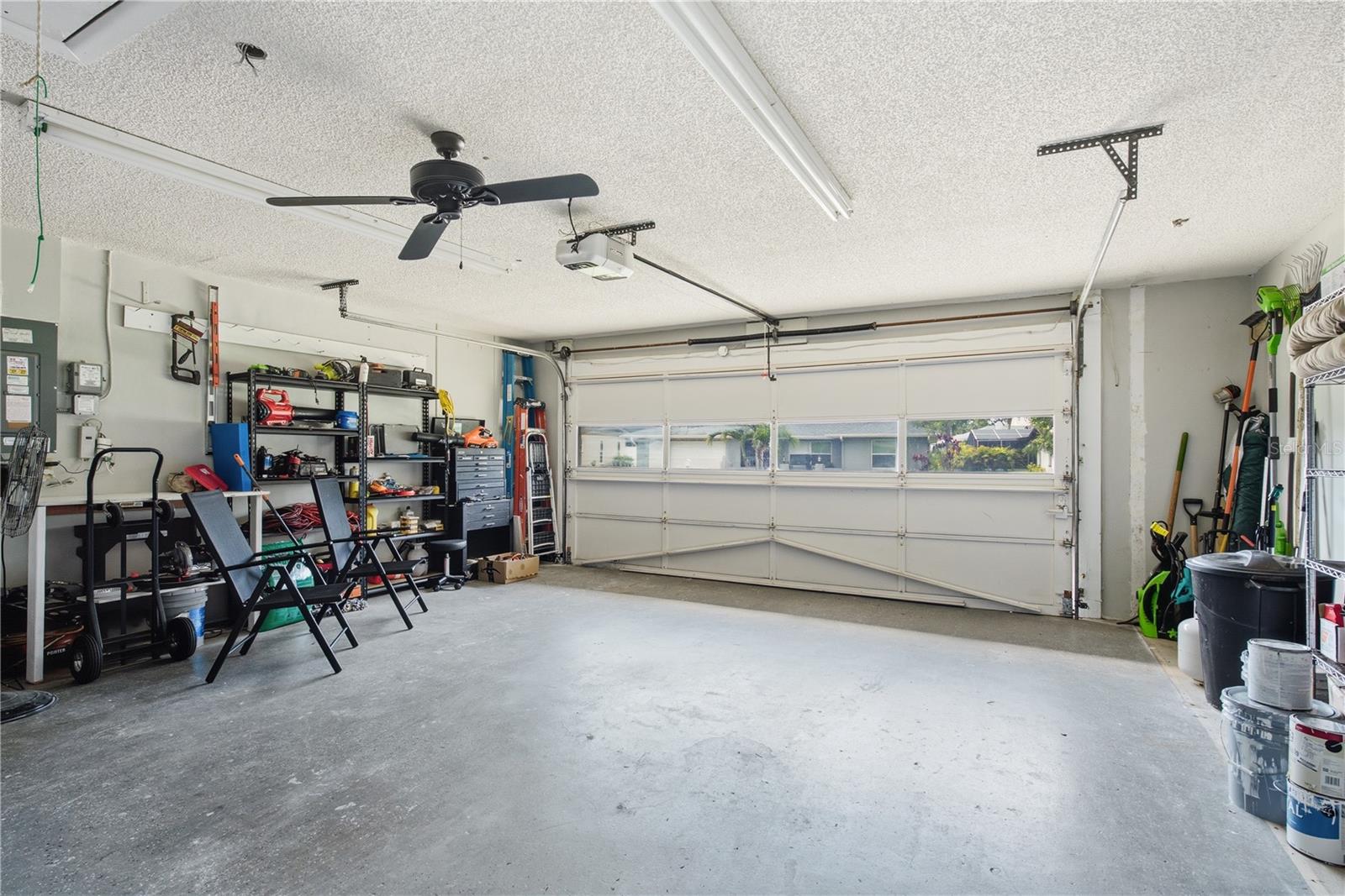 2 car garage equipped with an automatic door opener, overhead ceiling fan, and plenty of room for storage or a workshop.