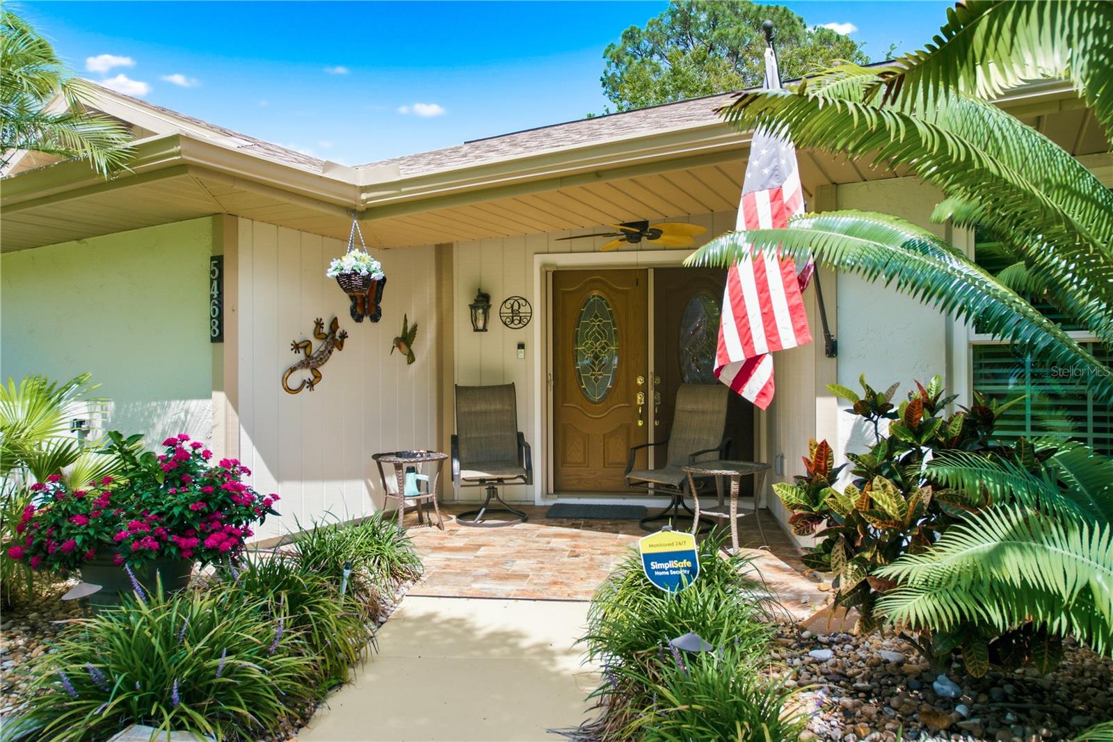 A welcoming front entryway featuring a cozy covered patio area, perfect for relaxing outdoors.