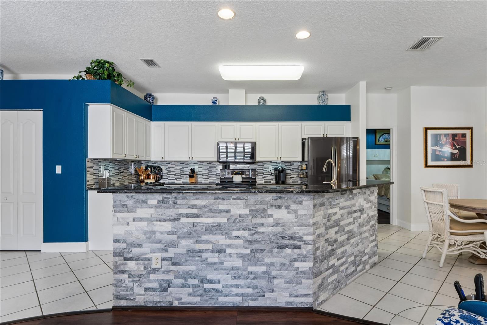 PLENTY OF ROOM FOR FAMILY AND FRIENDS AROUND THE KITCHEN BAR