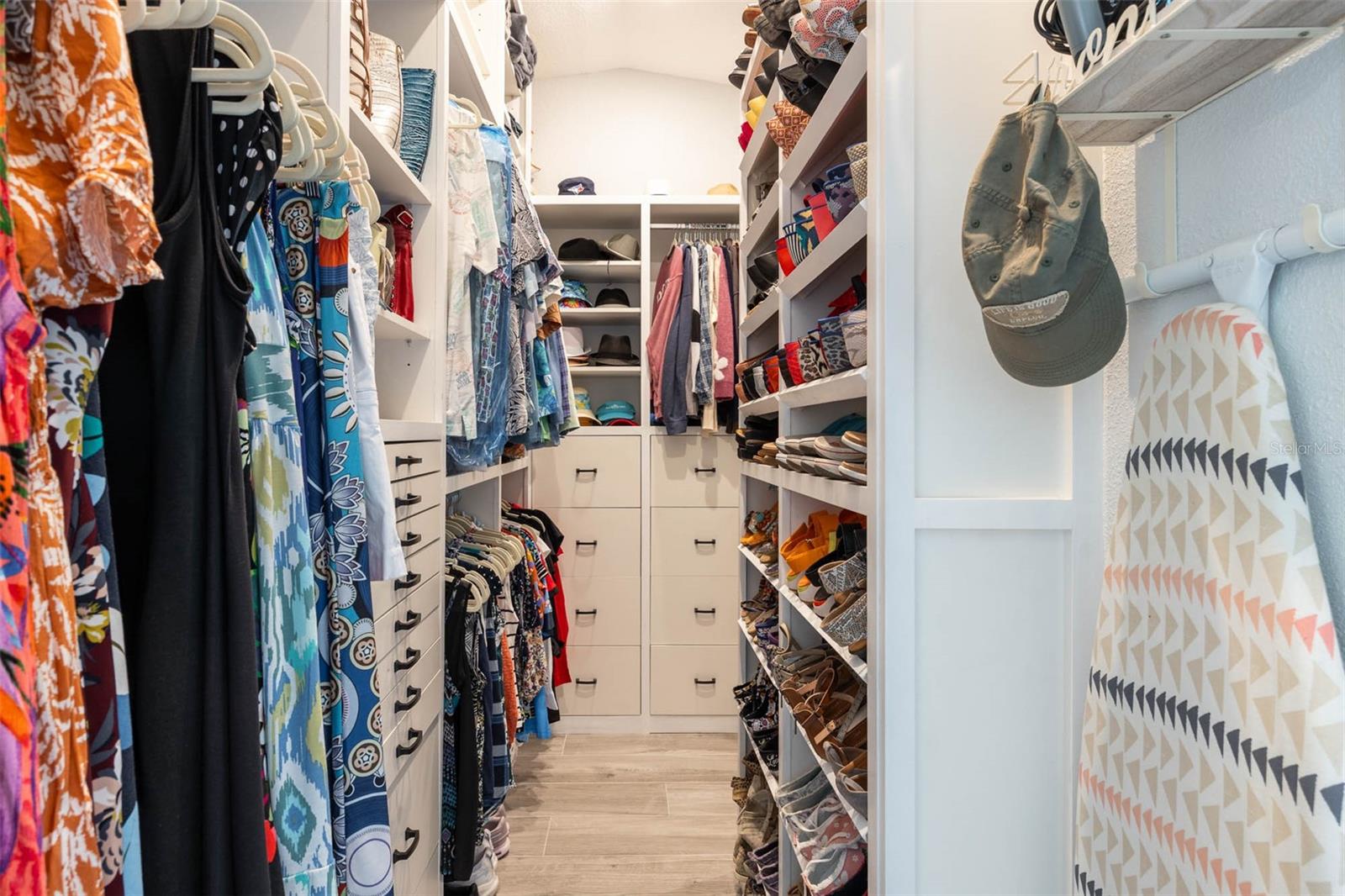 Custom closet organizer runs floor to ceiling to maximize storage options.