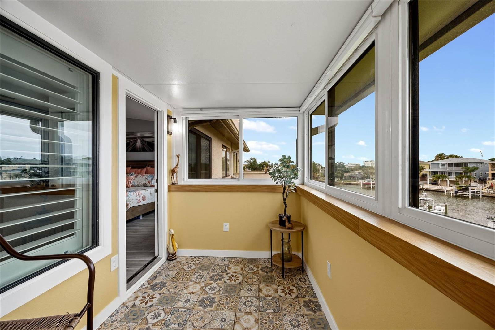 Balcony off of the Primary Suite with newer insulated roof and hurricane windows and gorgeous custom tile flooring.