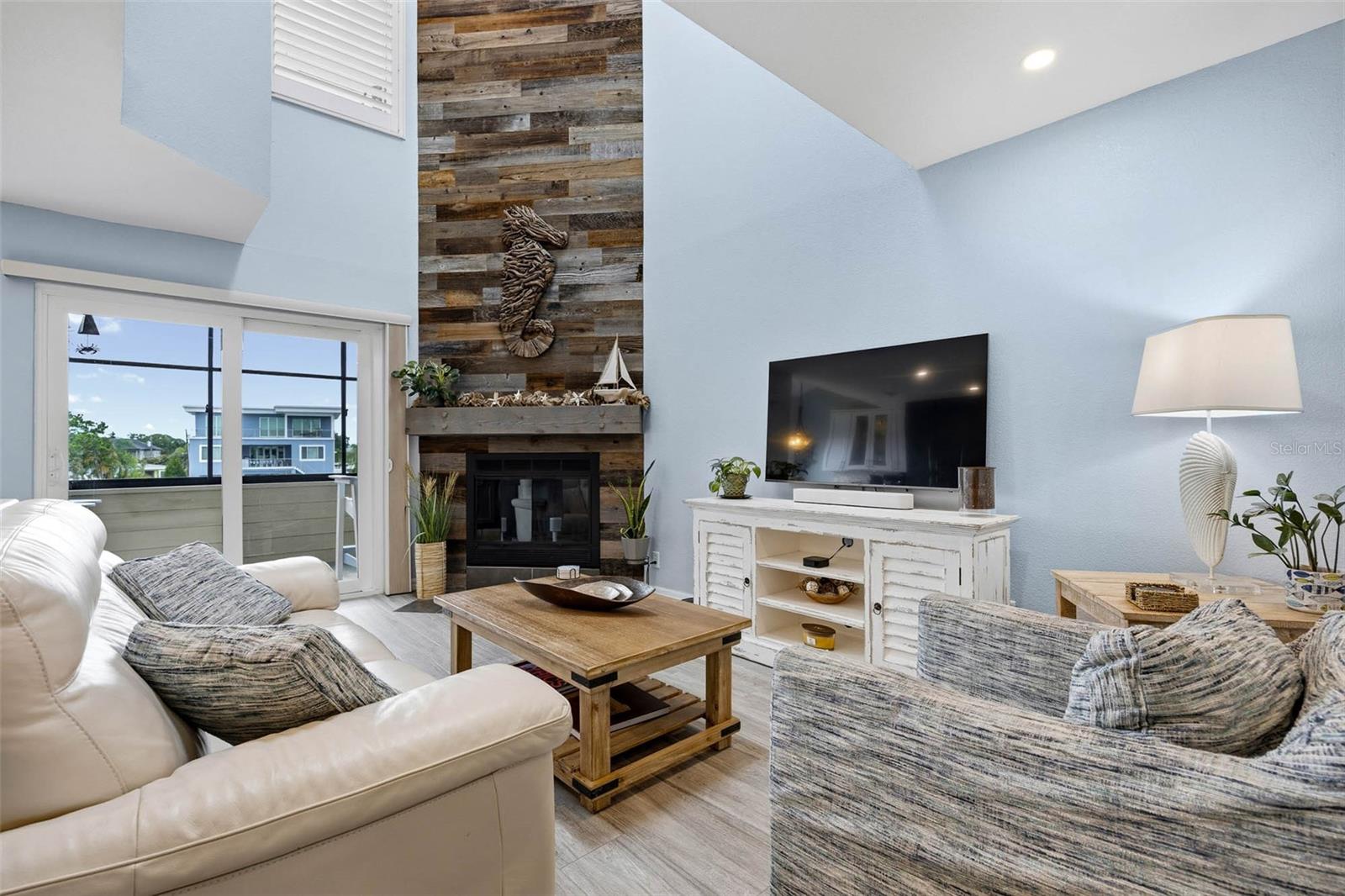 Main floor Living Room with vaulted ceiling and impressive fireplace with wood accent wall.