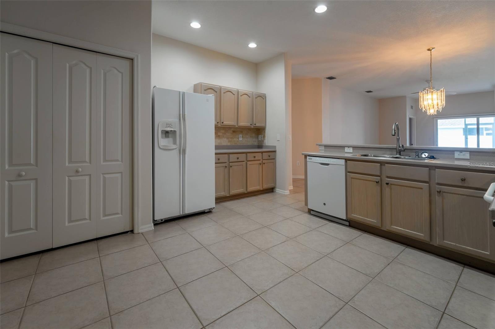 View of Refrigerator, dishwasher and Laundry Closet on left