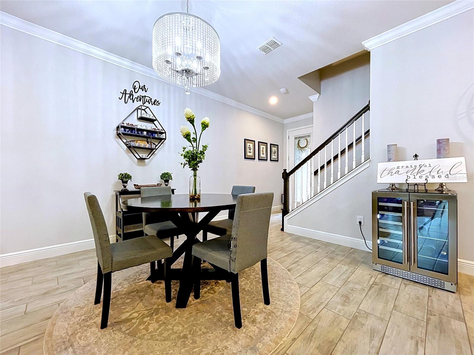 Perfectly positioned near the entry, the spacious dining area offers an inviting setting for everyday meals and special gatherings. A sparkling chandelier and neutral finishes create a sophisticated yet comfortable atmosphere.
