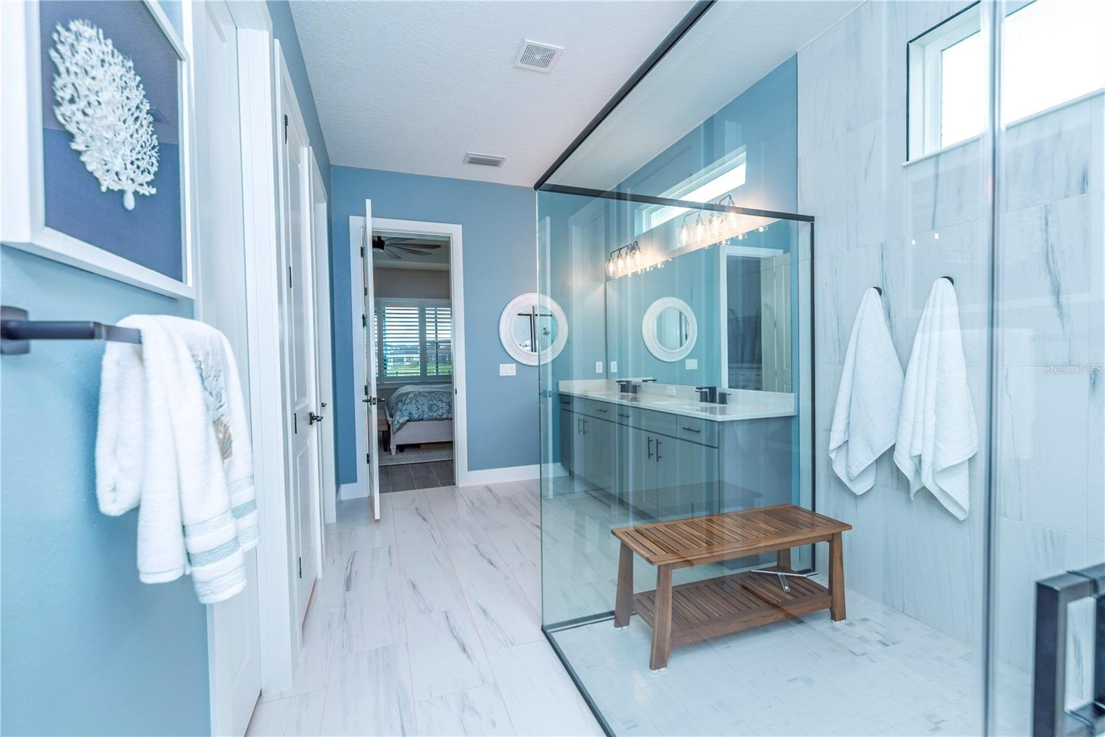 Primary ensuite bathroom with large shower and walk-in closet.