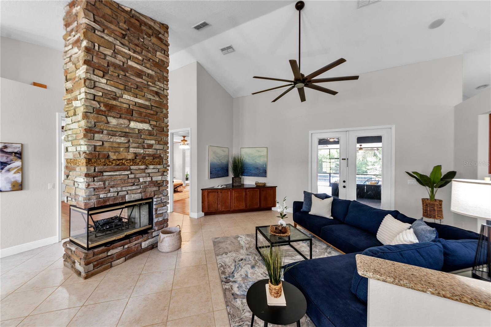 3 sided fireplace, cathedral ceiling and built in TV stand and French Doors