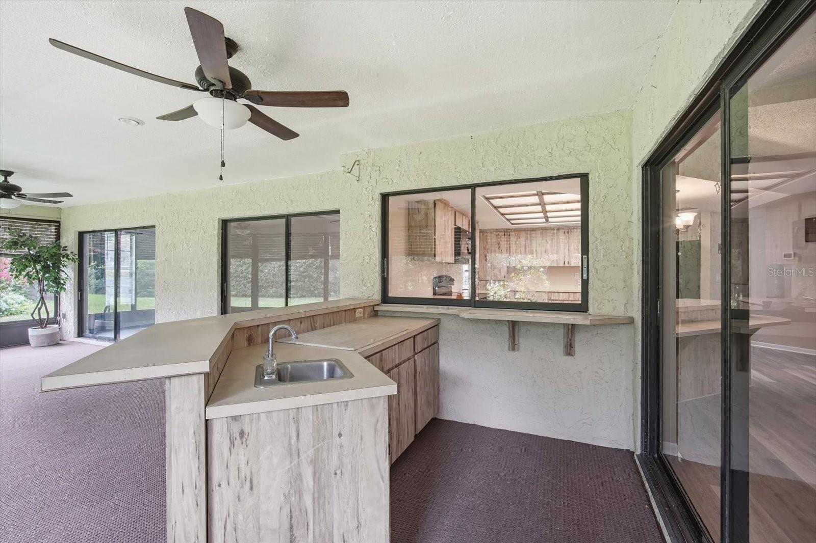 Massive outdoor covered, screened lanai with outdoor kitchen and ceiling fans
