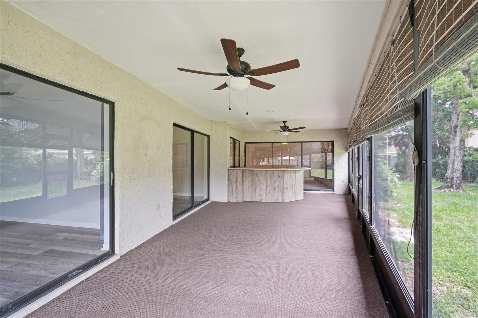 Massive outdoor covered, screened lanai with outdoor kitchen and ceiling fans