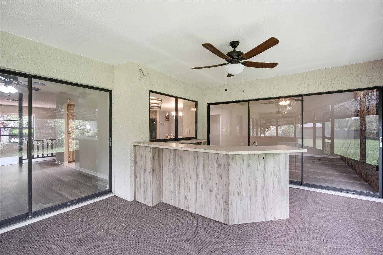 Massive outdoor covered, screened lanai with outdoor kitchen and ceiling fans