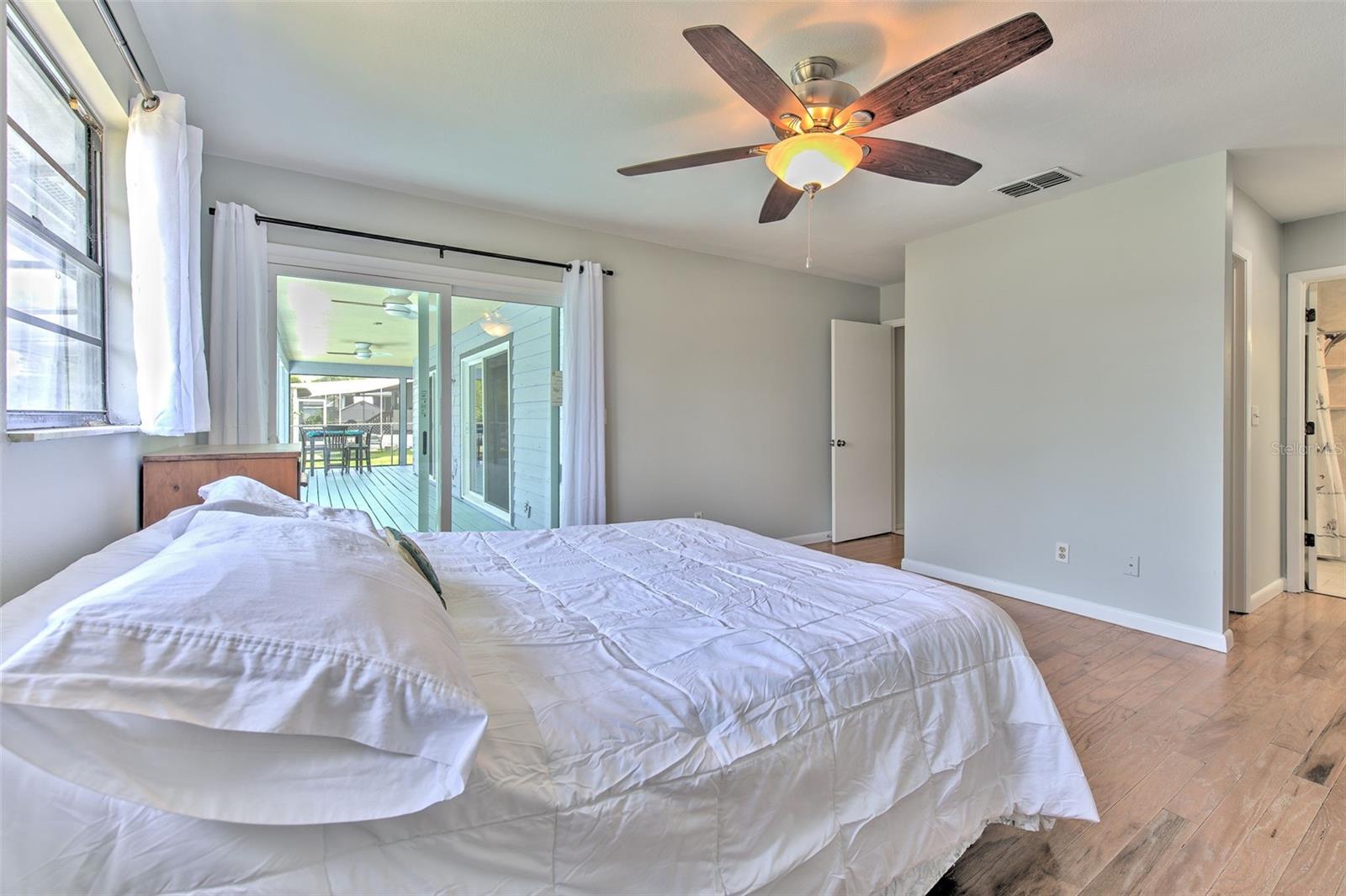 Master Bedroom with Backyard Lake views and slider doors to screened in patio