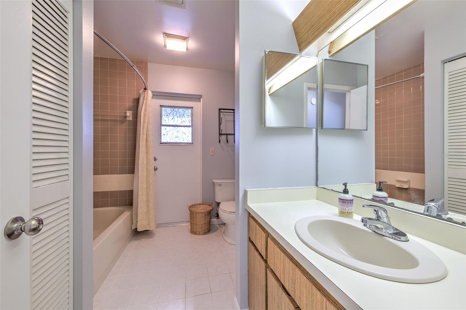 Bathroom with ensuite access to bedroom 2, access to hallway and exit door to screened in patio