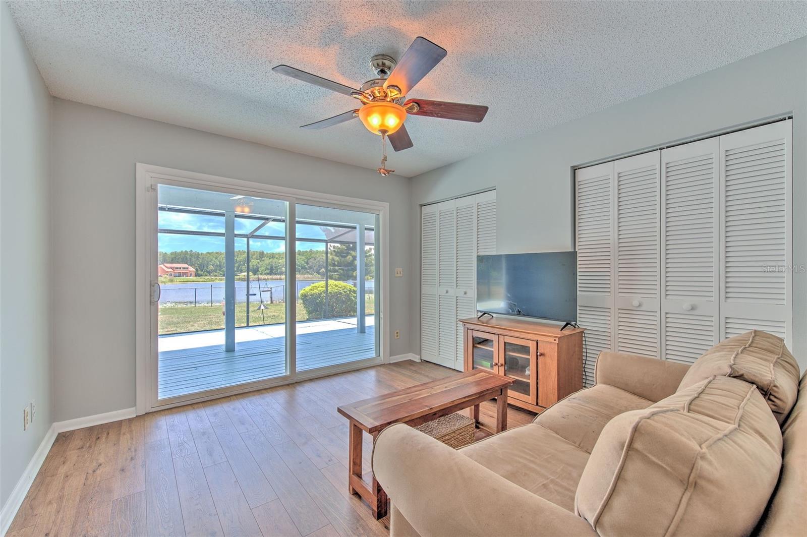 Bedroom 3 with view of Lake and backyard and slider doors to back screened in patio